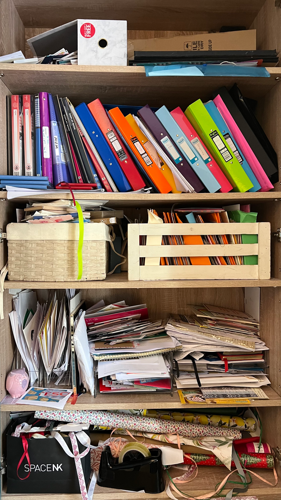 Office shelves crowded with paperwork and old files before a home office organisation project. Professional organiser Hertfordshire, home office decluttering, and paperwork organisation.