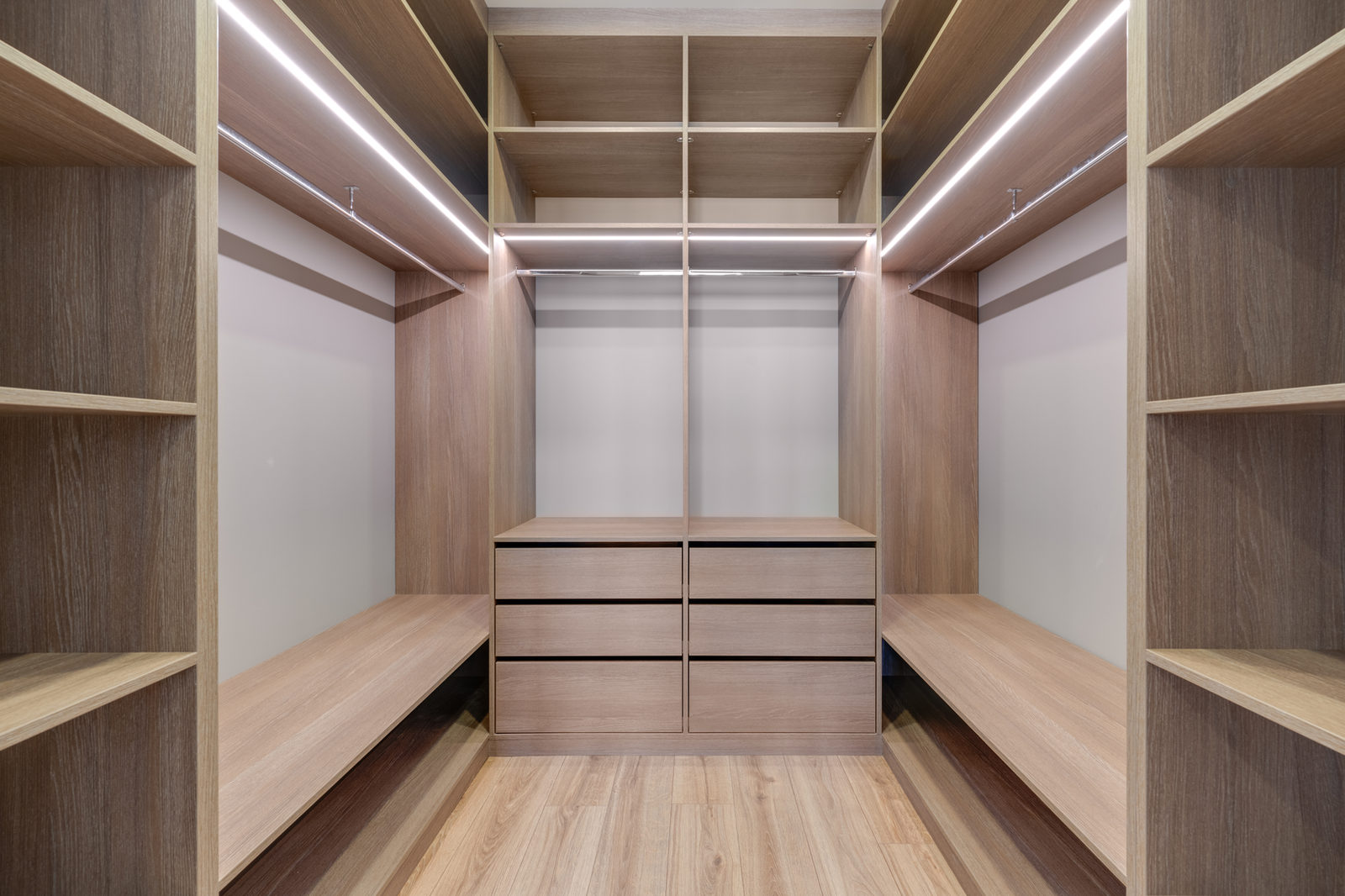 Spacious empty wardrobe with lighting and wooden shelves