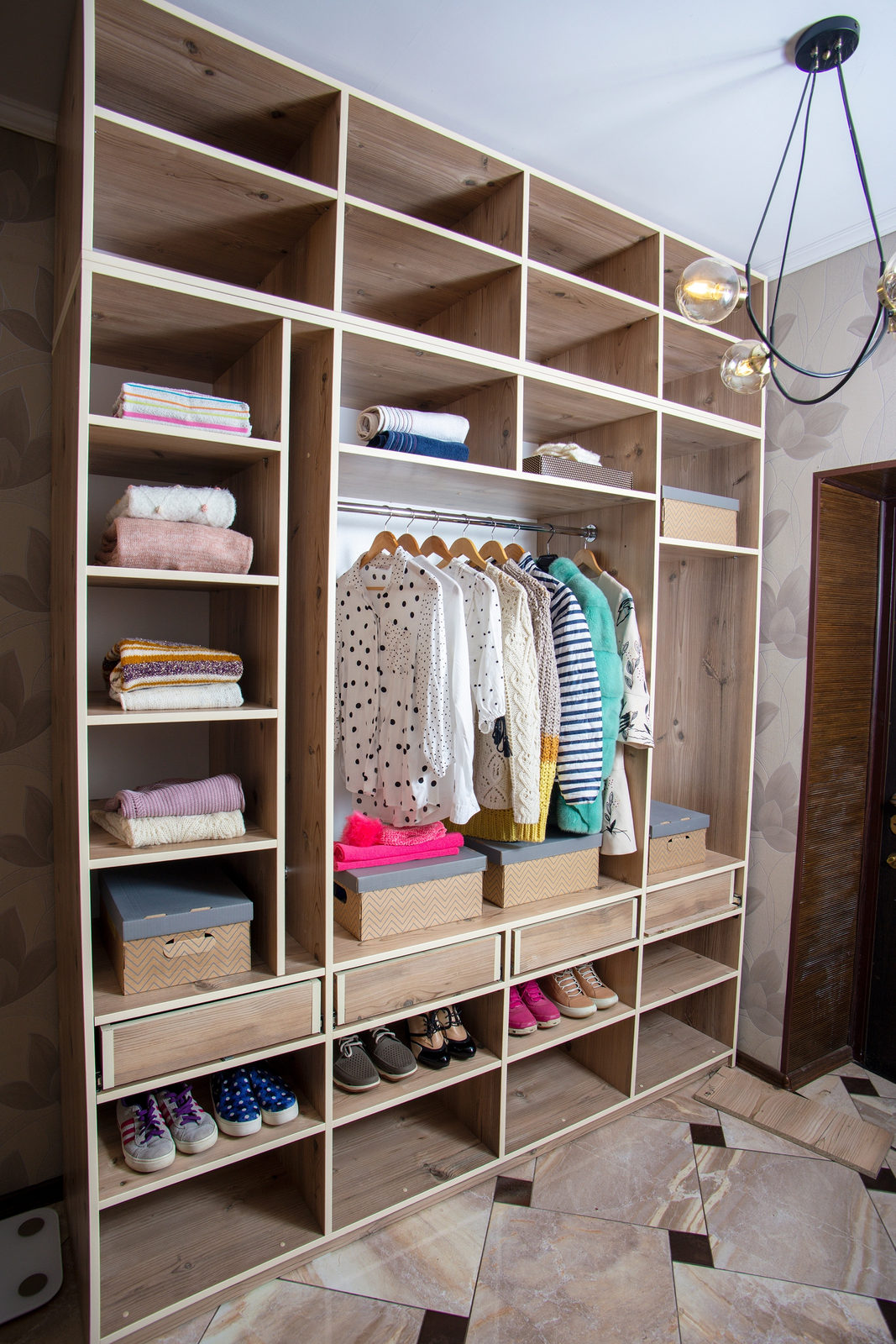 Organised fitted dressing room with clothes, shelving and shoe storage